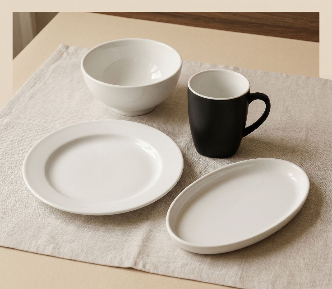 A set of Fourier bio-composite tableware grouped on a pale linen surface in warm daylight